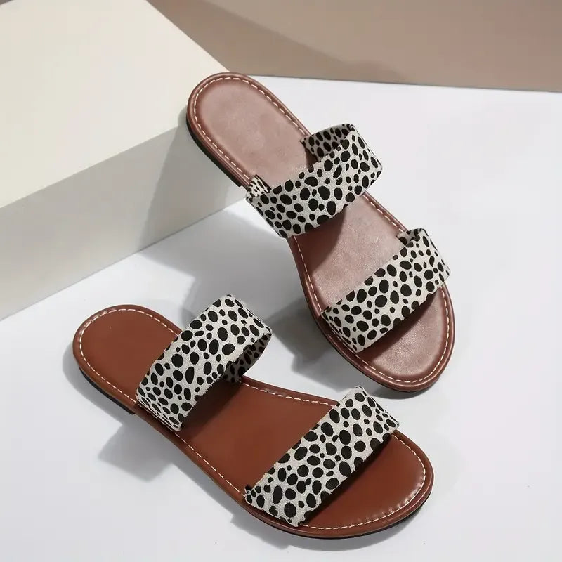 woopify-src:https://manager.labonas.com/wp-content/uploads/2025/07/chaussures-addict-sandales-plates-leopard-tendance.jpg|Paire de sandales plates Léopard de Chaussures Addict avec imprimé léopard tendance, posées sur une surface blanche.
